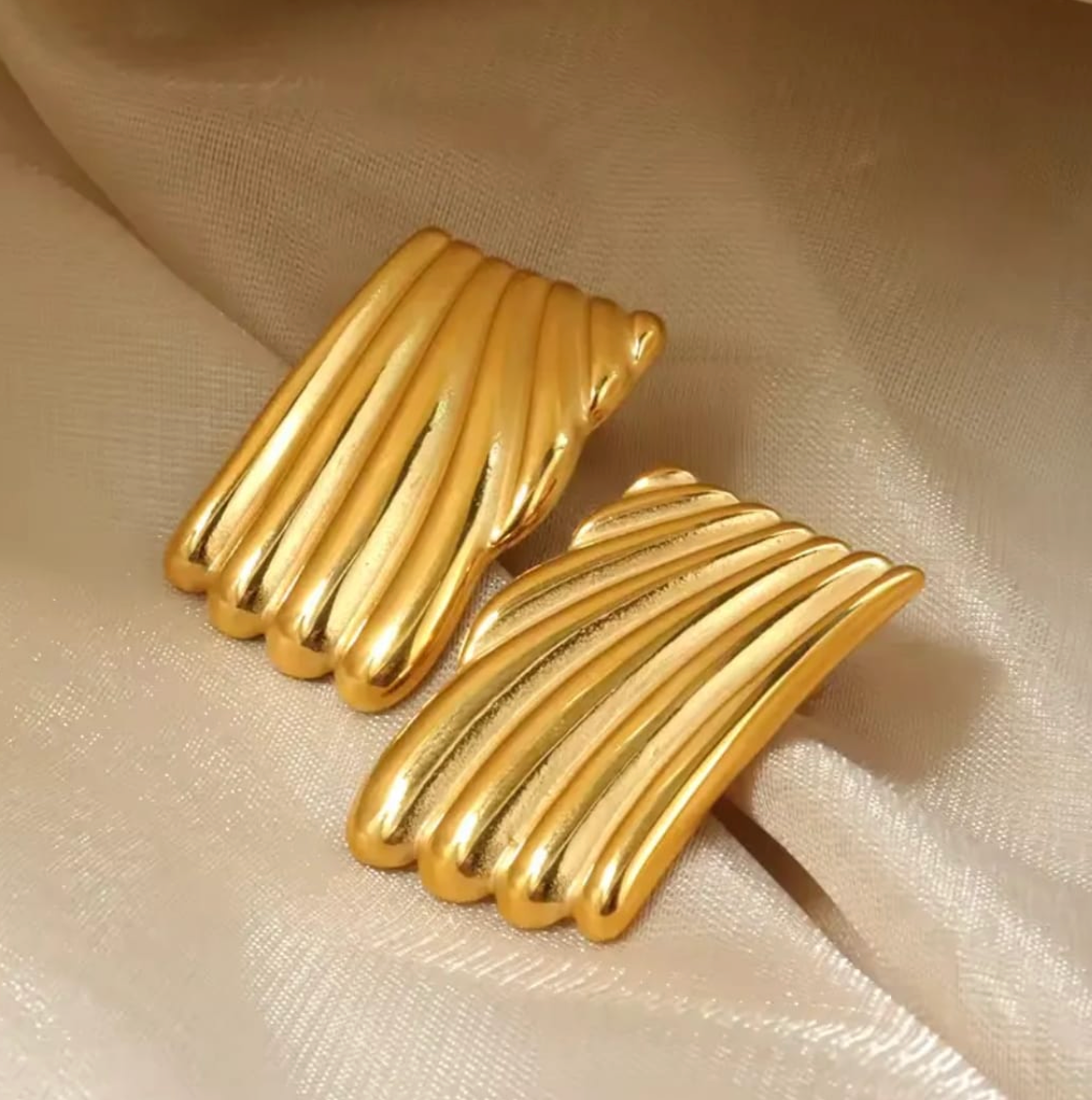 Vintage-inspired gold statement stud with twisted ribbed texture, on-ear view.